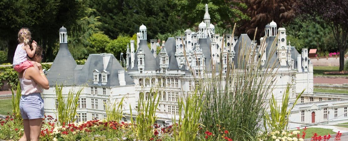 Une maman et sa fille devant modèle réduit, dans le Parc Mini Châteaux