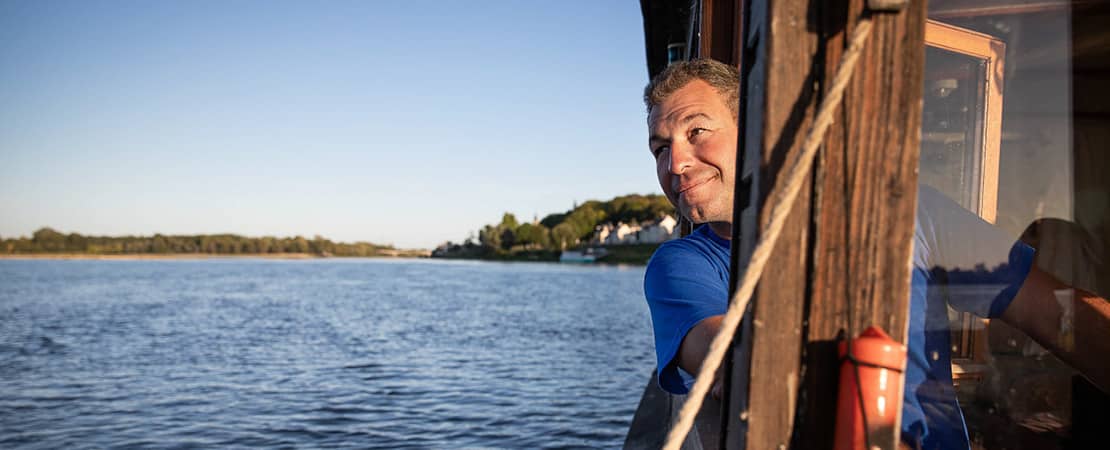 Homme sur un bateau qui vogue au fil de l'eau