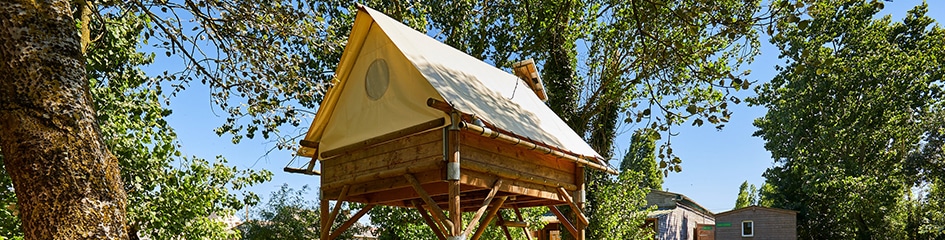 Vue sur une cabane perchée dans le camping