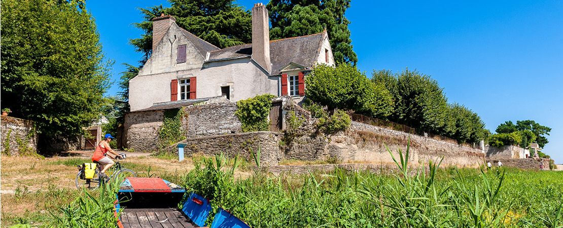 Cycliste sur un chemin devant une maison