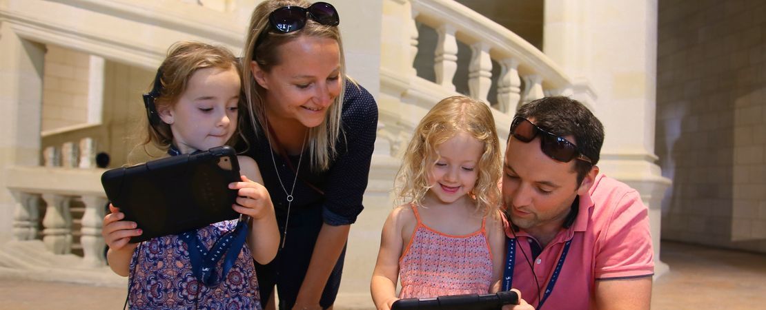 Famille dans le château avec tablettes tactiles