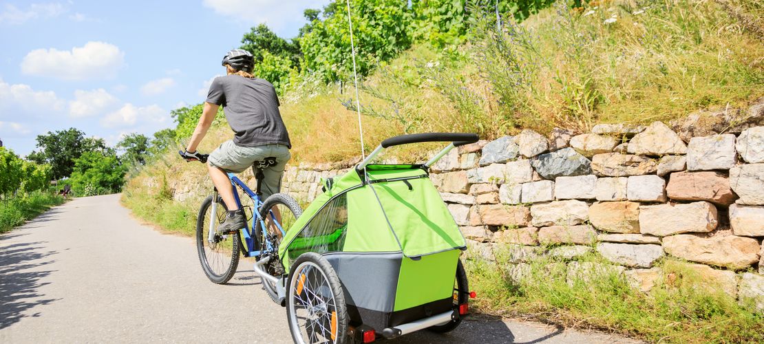 Homme sur un vélo avec une remorque accochée
