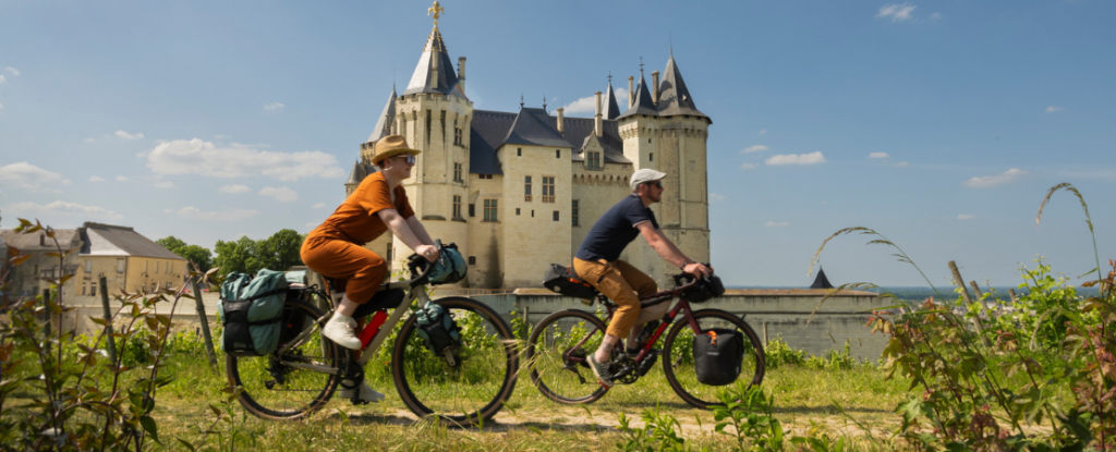 Personnes à vélo devant un château