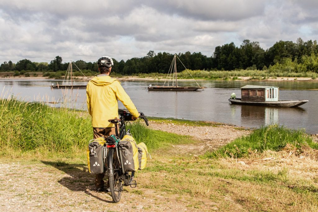 Cyclotouriste en bord de Loire avec bateaux